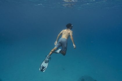 man freediving with flippers underwater